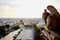 Norte dame gargoyle looking out over Paris at sunset