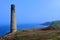 North Cornish Coast with Levant Tin Mine chimney and Pendeen Lighthouse in distance, Cornwall 