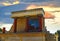 North Entrance of the Knossos Palace complex with charging bull fresco and red columns, with red orange sunset clouds in