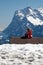 North face of the Eiger, Swiss Alps with young girl on hut roof.