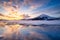 North, Norway. Winter landscape during sunset. Bright sky. Ice and snow on the shore. Reflections on the ice surface. Snowy winter