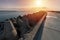 North pier with breakwaters, sunset seascape, Modern lighthouse in sunlight, Tetrapods along edges of pier, Beautiful evening