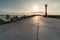 North pier with breakwaters, sunset seascape. Modern lighthouse in sunlight. Tetrapods along edges of pier. Beautiful evening