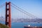 The north tower of Golden Gate Bridge; San Francisco`s skyline visible in the background; large cargo ship passing under the