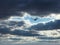 Northern Harrier Soars in Clouds: A soaring northern harrier bird of prey on a fall day as the sun begins to shine through thick