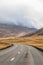 Northern Iceland empty road winding through valley upwards a mountain during grey weather