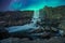 Northern lights/aurora borealis are dancing over the famous oxarafoss waterfall at night in thingvellir