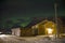 The northern lights aurora borealis seen behind a home in a small village in the north of Norway. In the middle of winter.
