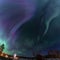 Northern Lights in the clear starry skies shines above Swedish countryside landscape. Green and blue Aurora Borealis stripes