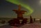 Northern lights and inukshuk with tourist