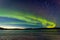 Northern Lights and morning dawn over frozen lake