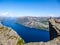 Norway - Boy sitting on a steep cliff with the view on Lysefjorden