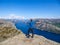 Norway - Boy standing on a steep cliff with the view on Lysefjorden