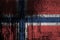 Norway flag depicted in paint colors on old and dirty oil barrel wall closeup. Textured banner on rough background