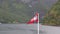 Norway flag waving on nature fjord of Norway
