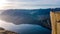 Norway - A girl standing at the edge of Preikestolen during the sunset