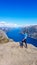 Norway - Girl standng on a steep cliff with the view on Lysefjorden