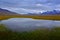 Norway typical landscape with lake and mountain. Landscape near Longyearbyen, Svalbard. Dark day in summer. Grey clouds on the sky