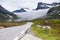 Norwegian asphalt road with hovering cloud between the mountains, on the road to Trollstigen, Norway
