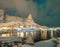 Norwegian fishing village with northern lights and stars in Reine City, Lofoten islands, Norway, Europe. White snowy mountain