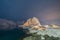 Norwegian fishing village with stars in Hamnoy City, Lofoten islands, Norway, Europe. White snowy mountain hills and trees at