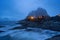 Norwegian fishing village at twilight in Hamnoy City, Lofoten islands, Norway, Europe. White snowy mountain hills and trees at