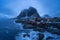Norwegian fishing village at twilight in Hamnoy City, Lofoten islands, Norway, Europe. White snowy mountain hills and trees at