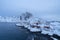 Norwegian fishing village at twilight in Hamnoy City, Lofoten islands, Norway, Europe. White snowy mountain hills and trees at