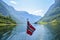 Norwegian flag against background of magnificent fjord landscape