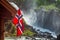 Norwegian flag against waterfall in Norway Scandinavia
