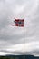 a norwegian flag flutters in the wind on top of a mountain