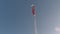 Norwegian flag, pennant, on flag pole in cold breeze in winter sunshine with clear blue sky background