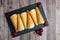 Norwegian Krumkake cookies on a slate plater, rustic wood background, red bows and bells