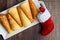 Norwegian Krumkake cookies on a white ceramic plater, rustic dark wood background, red and white Christmas stocking