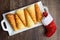 Norwegian Krumkake cookies on a white ceramic plater, rustic dark wood background, red and white Christmas stocking