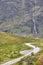 Norwegian mountain road landscape. Waterfall and cabin. Motorcycle travel.