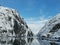 Norwegian sailing trollfjord and coast during a winter sail with snow