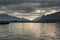 Norwegian seascape, lighthouse on the island, rocky coast with dramatic skies, the sun breaks through the clouds, sheer