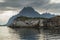 Norwegian seascape, lighthouse on the island, rocky coast with dramatic skies, the sun breaks through the clouds, sheer