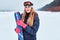 Norwegian woman wearing warm clothes posing with skis on a snowy beach