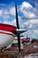 The nose of the aircraft with a propeller on the sky background