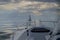 A nose of high-speed water boat in baltic sea with view of sailing vessel moves in a sea under the sails. View over the bow of hi