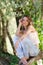 Nostalgic moments of a beautiful girl as she rests on a tree trunk