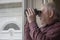 Nosy neighbor looking through window with binoculars