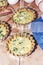 Not baked homemade quiche pie in mini metal forms served with fresh greens, kitchen towel