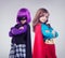 Not every girl wants to be a little princess. A studio shot of two little girls dressed up as a superhero and a villain.