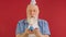 Not happy 60-year-old lonely elderly man with festive cone hat on his head celebrates his birthday, makes wish and