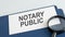 Notary public word on paper and magnifying lens