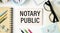 NOTARY PUBLIC is written in a white notepad near