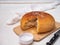 Notched homemade bread baked from coarse flour lies on a wooden kitchen board.